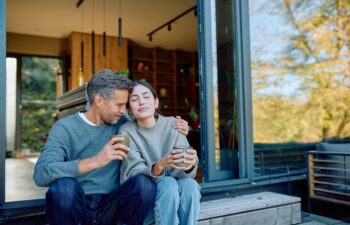 Couple embracing enjoying coffee relaxing on patio